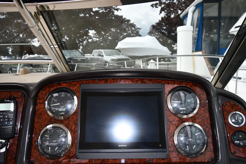 Slide: The Image of Dashboard of a 2004 Sea Ray 420 Sundancer with gauges and a Garmin display. - 13