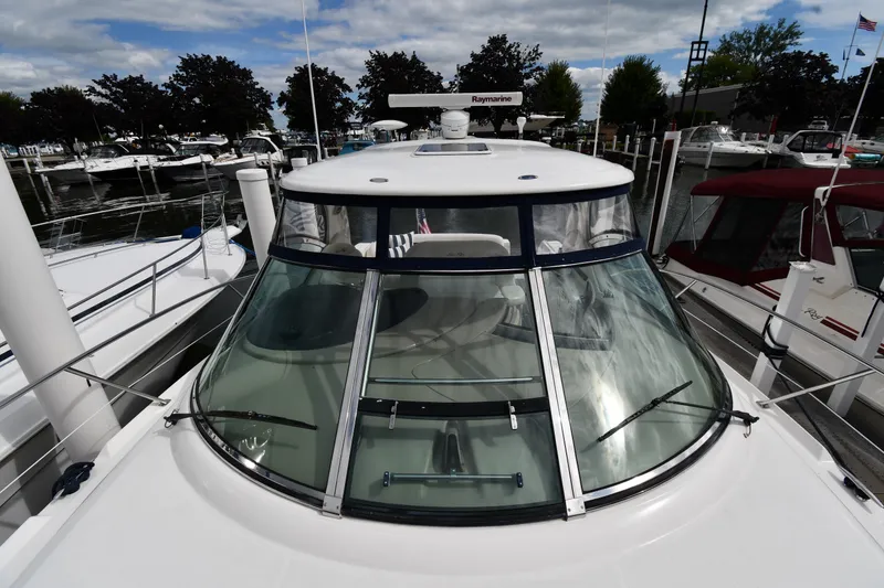 Slide: The Image of 2004 Sea Ray 420 Sundancer yacht docked at marina, showcasing sleek design and windshield. - 7