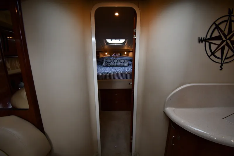 Slide: The Image of Interior view of 2004 Sea Ray 420 Sundancer cabin with bed and compass decor. - 25