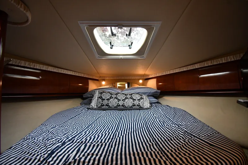 Slide: The Image of Luxurious cabin interior of 2004 Sea Ray 420 Sundancer with striped bedding and skylight. - 26