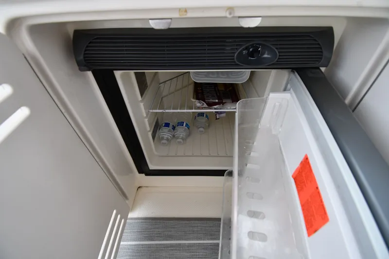 Slide: The Image of Open refrigerator inside 2004 Sea Ray 420 Sundancer yacht, containing water bottles and snacks. - 18