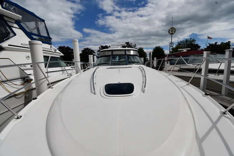 Slide: The Image of 2004 Sea Ray 420 Sundancer yacht docked under a partly cloudy sky. - 6