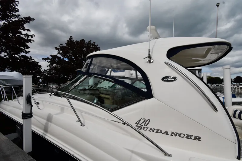 Slide: The Image of 2004 Sea Ray 420 Sundancer yacht docked under cloudy skies. - 3