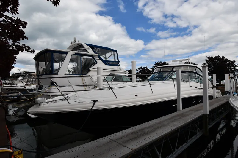 The Image of 2004 Sea Ray 420 Sundancer yacht docked at marina under cloudy sky. - 1