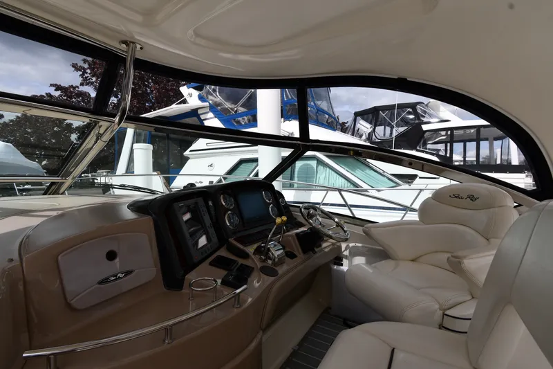 Slide: The Image of Interior view of 2004 Sea Ray 420 Sundancer yacht with luxurious seating and control panel. - 10