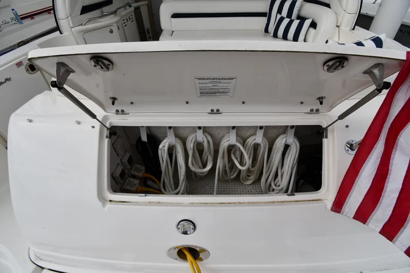 Slide: The Image of Open storage compartment on 2004 Sea Ray 420 Sundancer boat with coiled ropes and American flag. - 23
