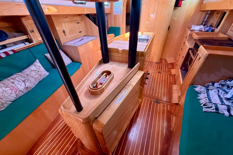 Slide: The Image of Interior of 2007 Chuck Burns Custom 49 Schooner with wooden finishes and green seating. - 13