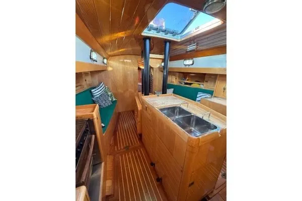 Slide: The Image of Interior of 2007 Chuck Burns Custom 49 Schooner with wooden finish and green seating. - 9