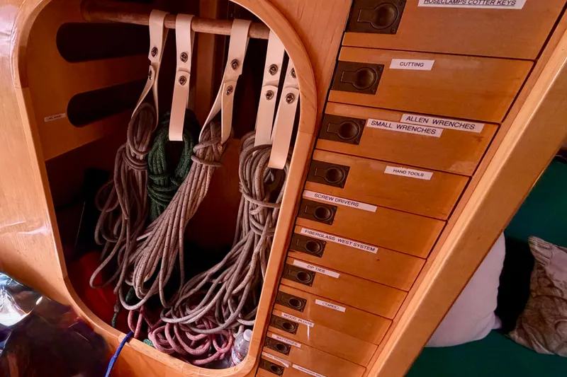 Slide: The Image of Storage area with ropes and labeled drawers on a 2007 Chuck Burns Custom 49 Schooner. - 26