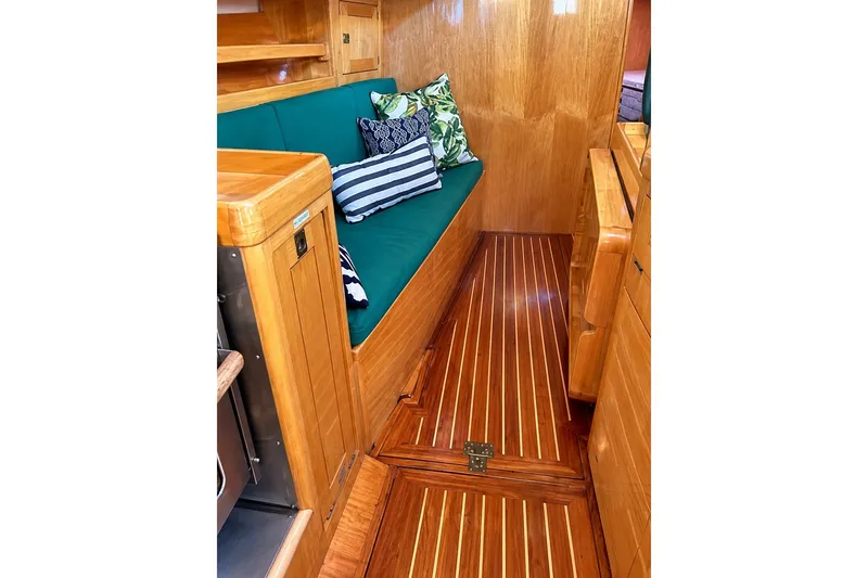 Slide: The Image of Luxurious wooden interior of 2007 Chuck Burns Custom 49 Schooner with green seating and decorative pillows. - 19