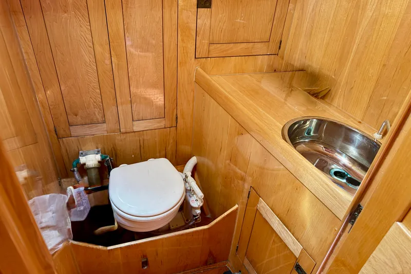 Slide: The Image of Wood-paneled bathroom with toilet and sink on 2007 Chuck Burns Custom 49 Schooner. - 21