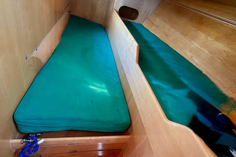 Slide: The Image of Interior of 2007 Chuck Burns Custom 49 Schooner with green cushioned seating. - 25