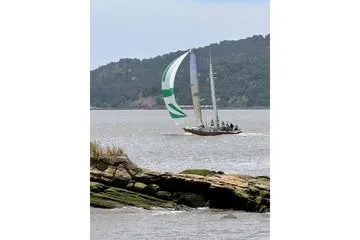 Slide: The Image of Sailing on a Chuck Burns Custom 49 Schooner, 2007, near rocky shoreline. - 2