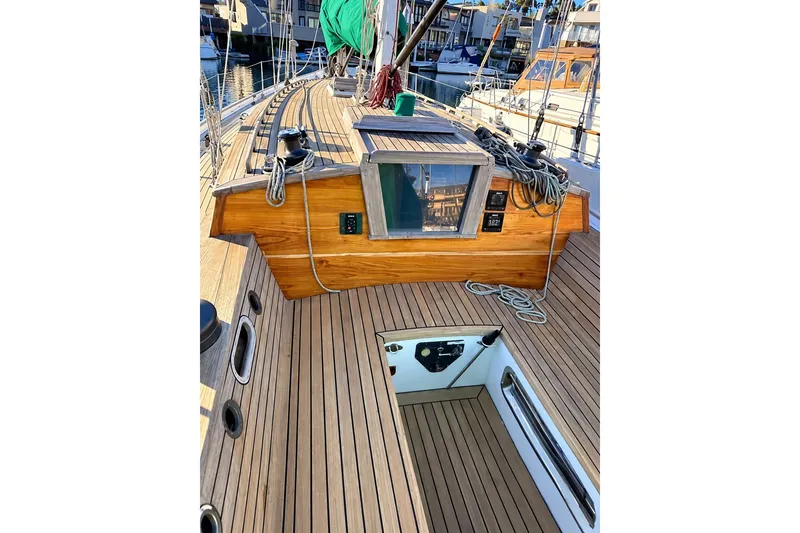 Slide: The Image of Wooden deck of a 2007 Chuck Burns Custom 49 Schooner, featuring ropes and hatch. - 9