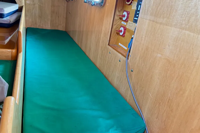 Slide: The Image of Interior of 2007 Chuck Burns Custom 49 Schooner with green cushion and control panel. - 23