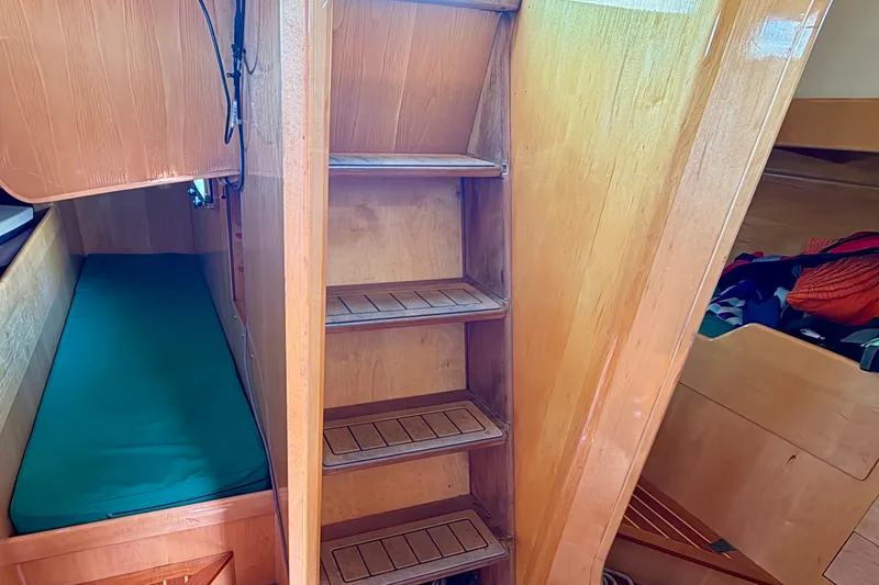 Slide: The Image of Interior of 2007 Chuck Burns Custom 49 Schooner with wooden stairs and cozy sleeping area. - 24