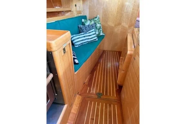 Slide: The Image of Interior of 2007 Chuck Burns Custom 49 Schooner with wooden flooring and teal seating. - 11