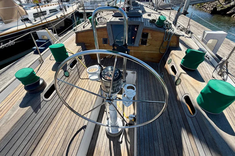 Slide: The Image of Steering wheel of a 2007 Chuck Burns Custom 49 Schooner, docked at a marina. - 7