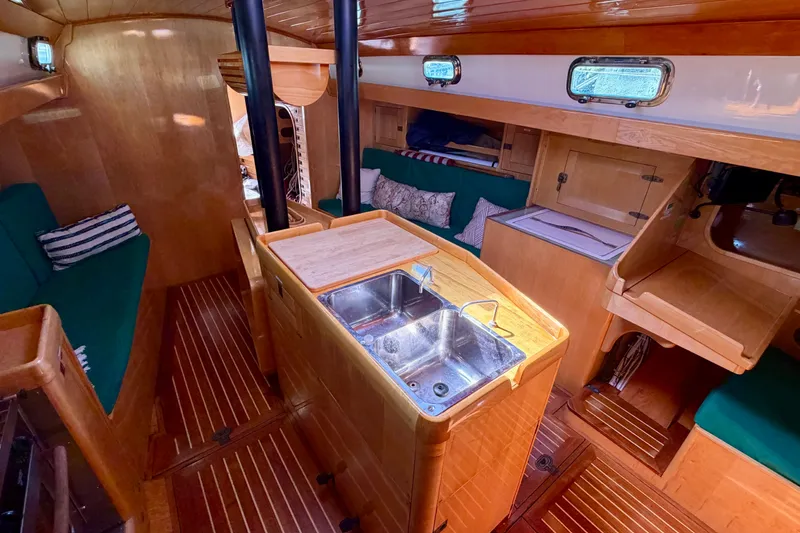 Slide: The Image of Interior of 2007 Chuck Burns Custom 49 Schooner with wooden finish and green seating. - 14