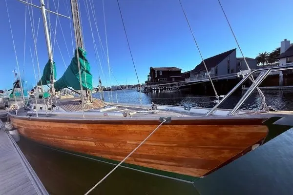 Slide: The Image of Custom 49 Schooner by Chuck Burns, 2007, docked with wooden hull and green sails. - 6