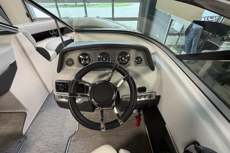 Slide: The Image of 2015 Regal 2300 Bowrider dashboard with steering wheel and gauges in a sleek interior. - 22
