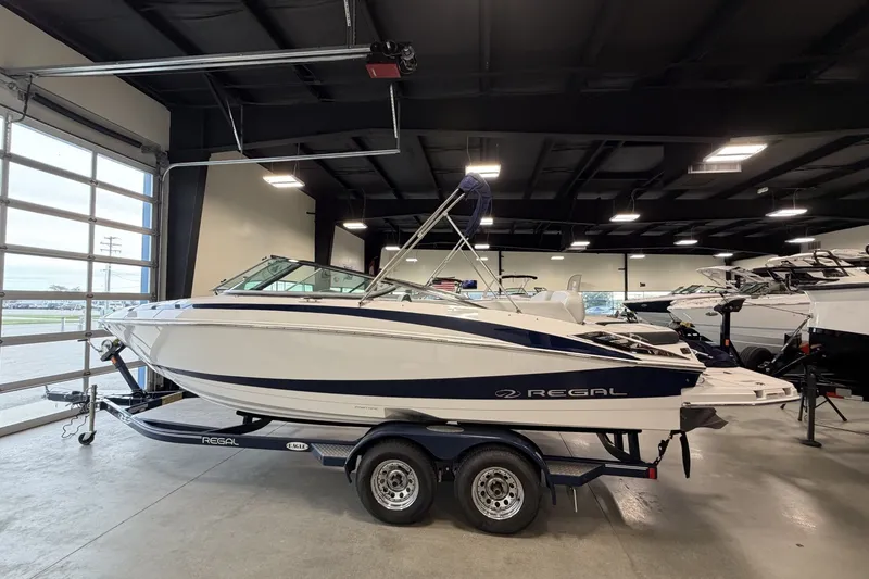 The Image of 2015 Regal 2300 Bowrider boat on trailer in showroom setting. - 0
