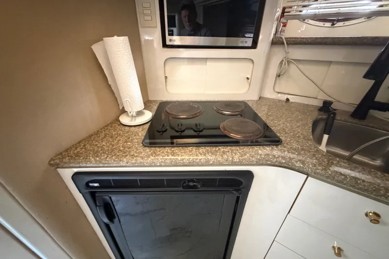 Slide: The Image of 1997 Maxum 4100 SCR yacht kitchen with stove, sink, and compact refrigerator. - 10