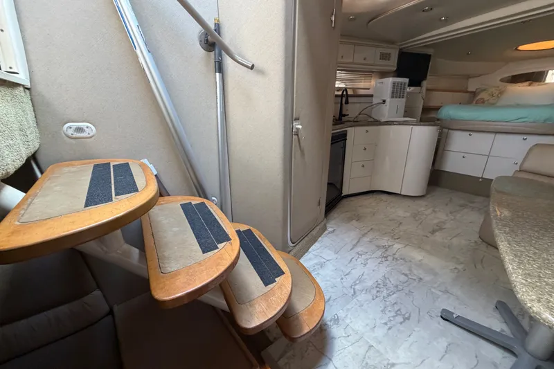 Slide: The Image of Interior of a 1997 Maxum 4100 SCR yacht, featuring stairs and a compact kitchen area. - 8
