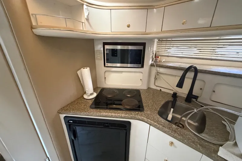 Slide: The Image of Compact kitchen in a 1997 Maxum 4100 SCR yacht with stove, sink, and microwave. - 9