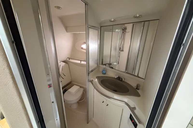 Slide: The Image of Bathroom interior of 1997 Maxum 4100 SCR yacht, featuring sink, toilet, and mirror. - 11