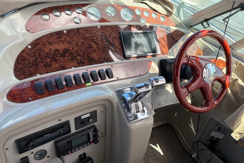 Slide: The Image of 1997 Maxum 4100 SCR boat dashboard with wood accents and modern controls. - 22