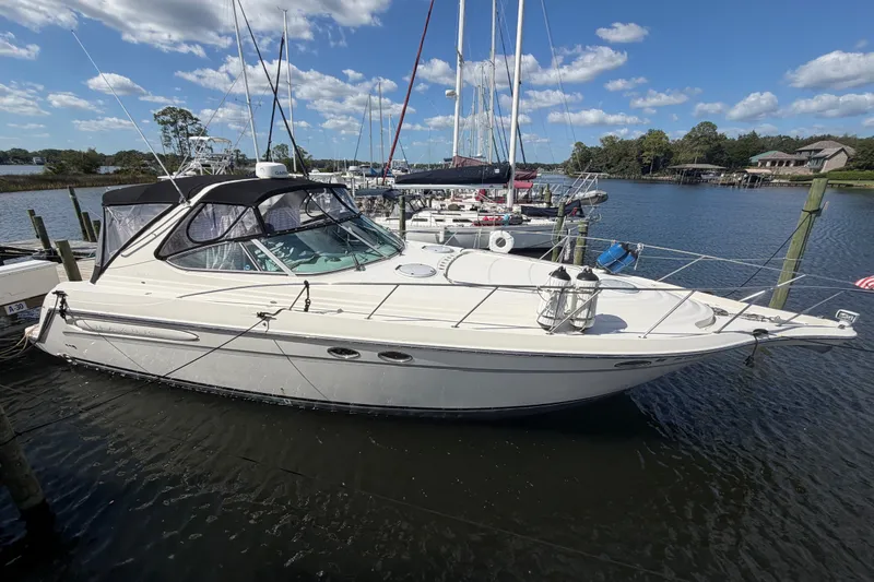 Slide: The Image of 1997 Maxum 4100 SCR yacht docked at a marina under a clear blue sky. - 0