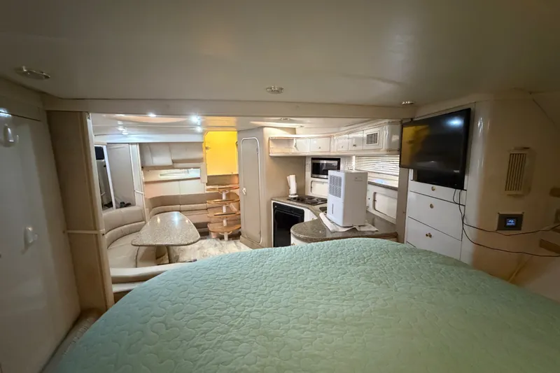 Slide: The Image of Interior of a 1997 Maxum 4100 SCR yacht, featuring a cozy living area and kitchenette. - 20