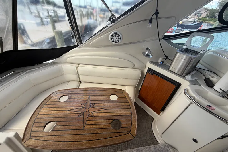 Slide: The Image of Interior of 1997 Maxum 4100 SCR yacht with wooden table and white seating. - 31