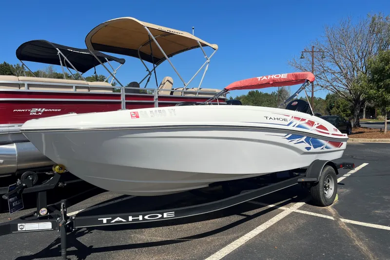 Slide: The Image of 2022 Tahoe T18 boat on trailer, parked outdoors under clear blue sky. - 1