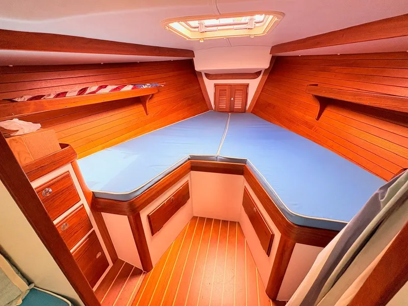 Slide: The Image of The cabin of the 2009 Alerion Express 38 features a V-shaped bed with wooden paneling. - 17