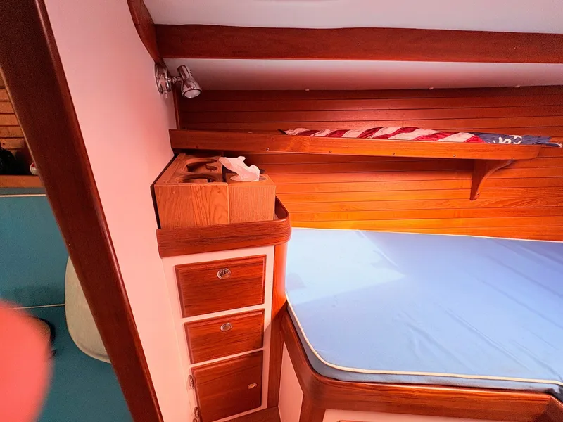 Slide: The Image of Interior of a 2009 Alerion Express 38 with wood paneling and a blue mattress. - 20