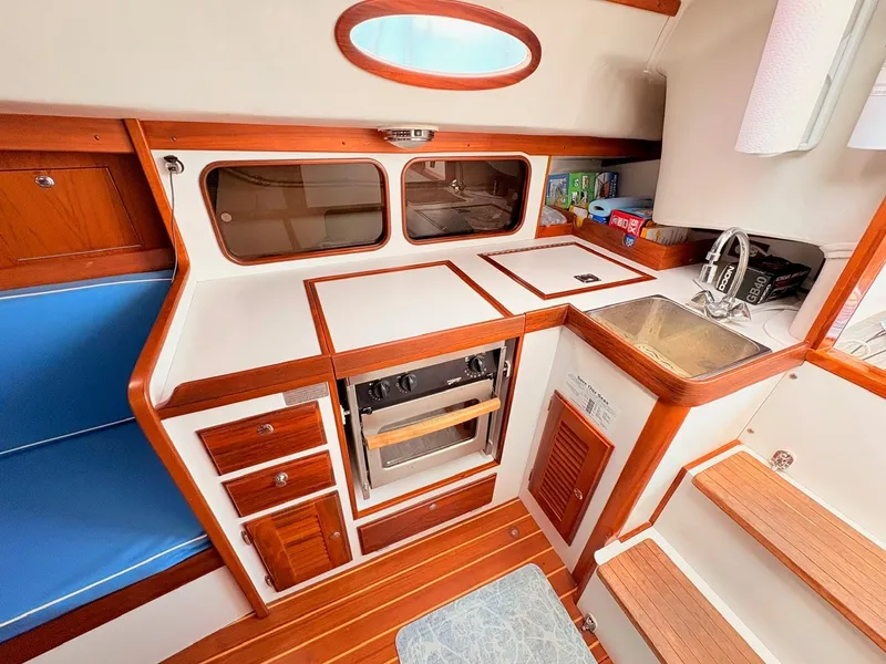 Slide: The Image of The galley of a 2009 Alerion Express 38 with wood trim, sink, and stove. - 8