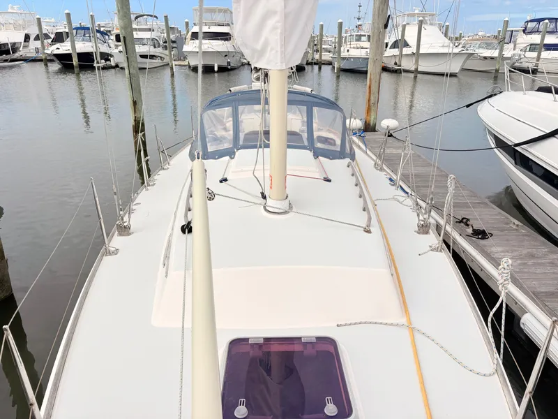 Slide: The Image of A 2009 Alerion Express 38 sailboat docked in a marina, surrounded by other boats. - 21