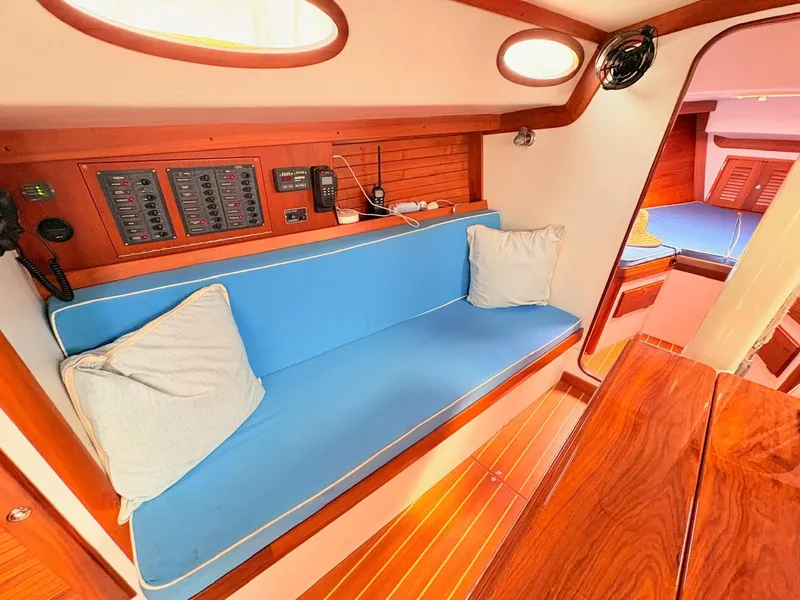 Slide: The Image of The cabin of a 2009 Alerion Express 38 with a blue bench and wooden flooring. - 11