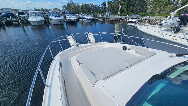 Slide: The Image of The image shows the foredeck of a 2024 Sea Ray Sundancer 320 Outboard docked in a marina. - 33