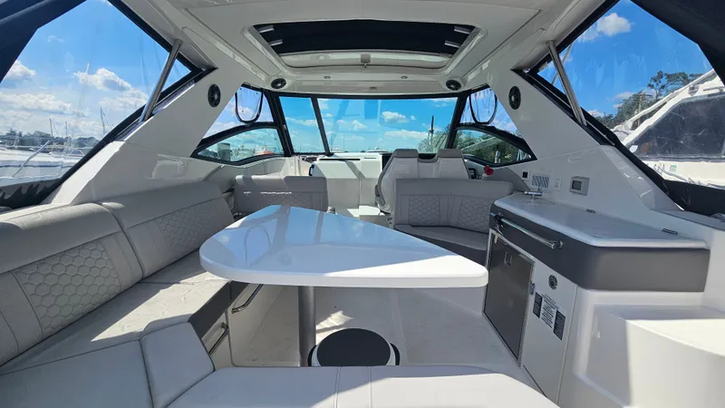 Slide: The Image of Interior of a 2024 Sea Ray Sundancer 320 Outboard with elegant seating area and table. - 9