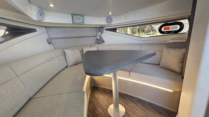 Slide: The Image of Interior of the 2024 Sea Ray Sundancer 320 Outboard with gray upholstered seating and table. - 23