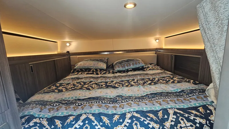 Slide: The Image of The image shows a cozy cabin with a large bed, decorated with patterned pillows and blankets. - 29