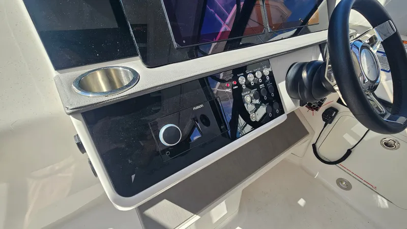 Slide: The Image of The image shows the helm of a 2024 Sea Ray Sundancer 320 Outboard with modern controls. - 19