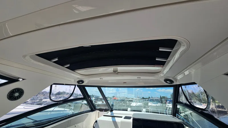 Slide: The Image of The image shows the interior of a 2024 Sea Ray Sundancer 320 Outboard with a large sunroof. - 11