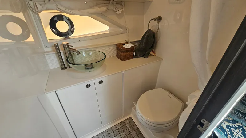 Slide: The Image of The image shows a sleek boat bathroom with a glass sink and toilet. - 27