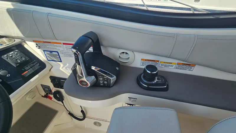 Slide: The Image of The image shows the cockpit of a 2024 Sea Ray Sundancer 320 Outboard with throttle and controls. - 20