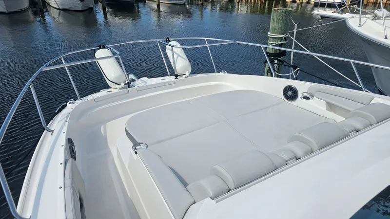 Slide: The Image of The image shows the spacious sun deck of a 2024 Sea Ray Sundancer 320 Outboard at a marina. - 32