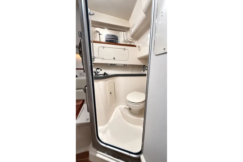 Slide: The Image of 2008 Grady-White Express 330 boat bathroom interior with toilet and storage cabinets. - 35